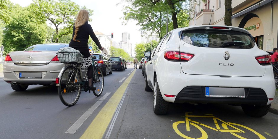 Kein Abstand: Die Radspur ist zugeparkt, die Radlerin muss auf die Straße ausweichen. Kommt leider allzu häufig vor.