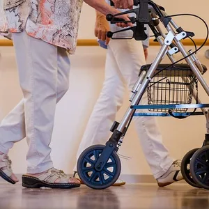 Eine Frau mit Rollator in einem Pflegeheim
