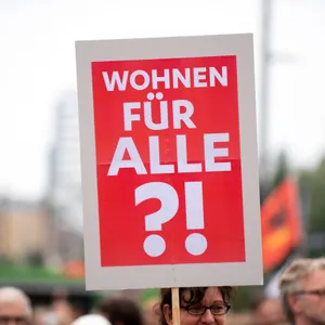 "Wohnen für Alle?!" steht auf einem Protestschild.