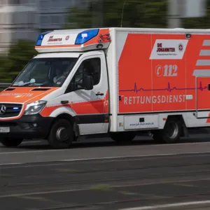 Mit eingeschaltetem Blaulicht fährt ein Rettungswagen über die Straße.
