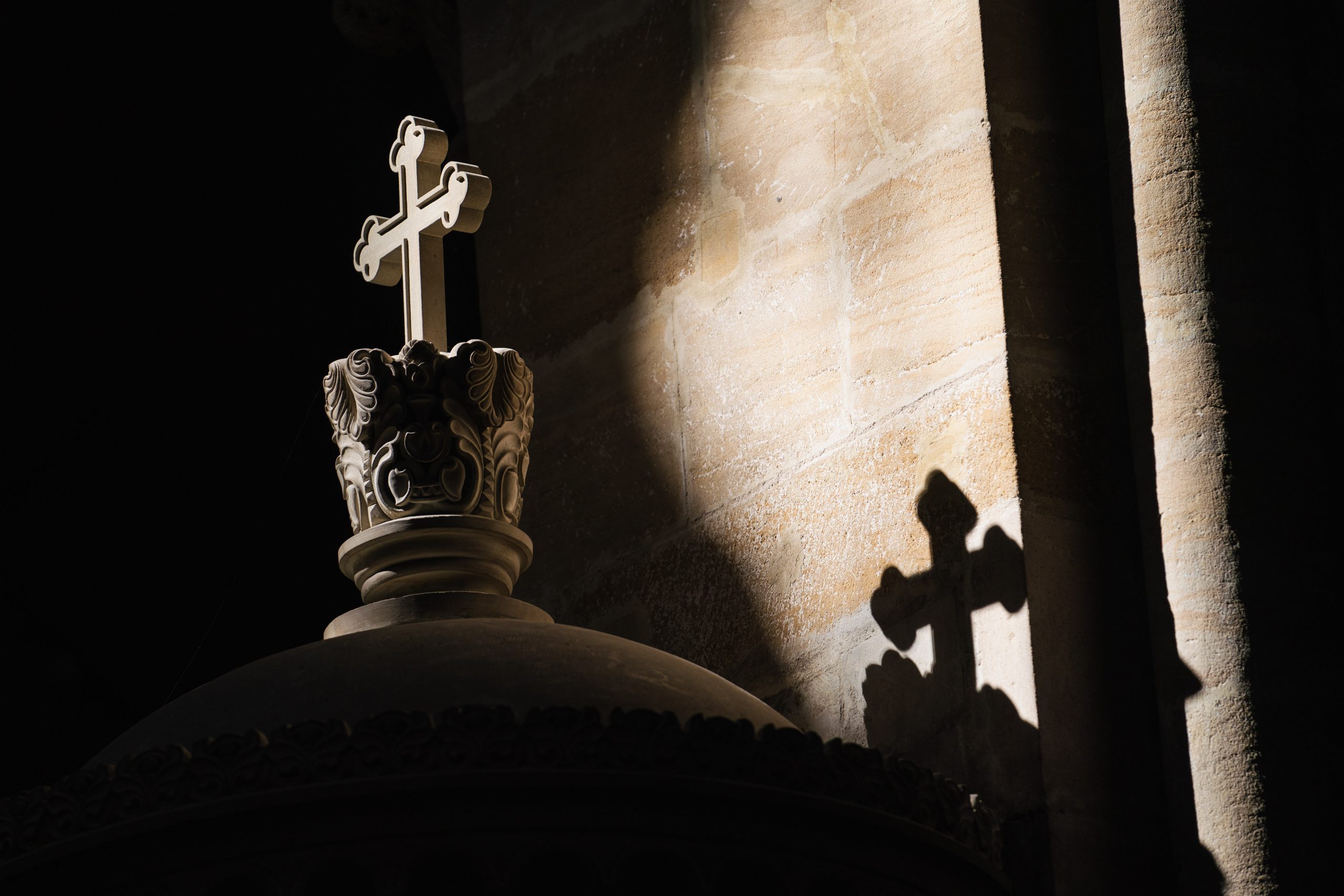 Ein Lichtstrahl fällt im Bamberger Dom auf ein Kreuz.