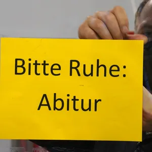 Lehrer bringt ein „Bitte Ruhe: Abitur“-Schild an