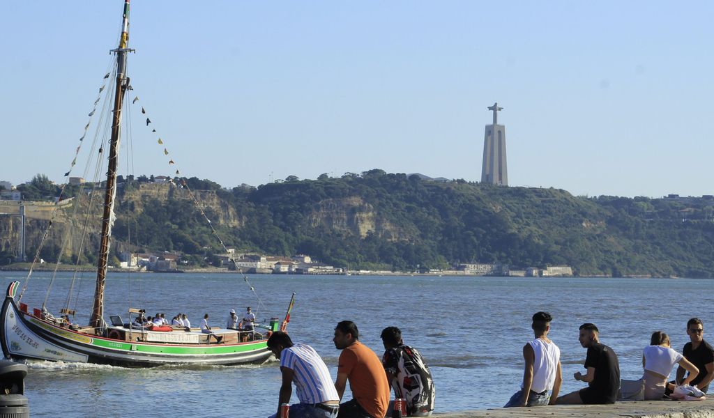Menschen sitzen an der Küste in Cais do Sodre in Lissabon, Portugal. Wegen der starken Verbreitung der Delta-Variante des Coronavirus müssen Rückkehrer für zwei Wochen in Quarantäne.