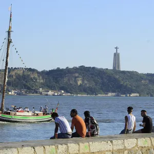 Menschen sitzen an der Küste in Cais do Sodre in Lissabon, Portugal. Wegen der starken Verbreitung der Delta-Variante des Coronavirus müssen Rückkehrer für zwei Wochen in Quarantäne.