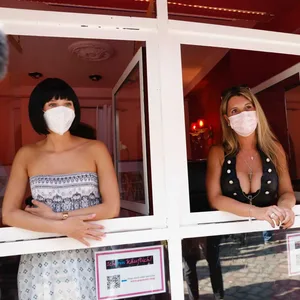 Die Sexarbeiterinnen Laura (l.) und Jenny schauen aus einem Fenster in der Herbertstraße.