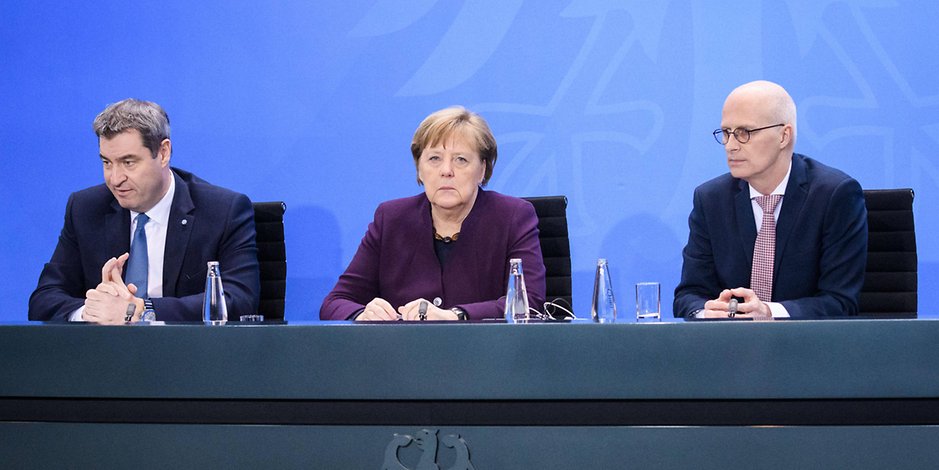 Bundeskanzlerin Angela Merkel sitzt zwischen Markus Söder (l.) und Peter Tschentscher.