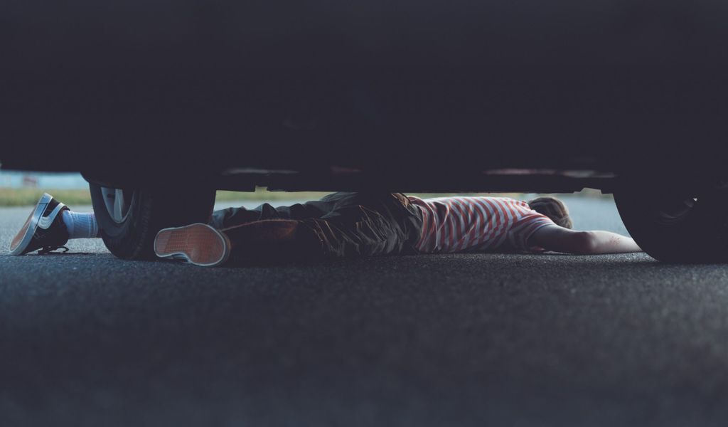 Ein Kind ist unter einem Auto eingeklemmt. (Symbolbild)