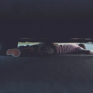 Ein Kind ist unter einem Auto eingeklemmt. (Symbolbild)