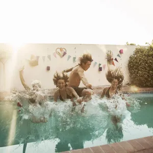Jugendliche springen in einen Pool.
