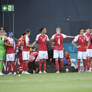 Die dänische Mannschaft steht um den am Boden liegenden Christian Eriksen.