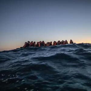 Migranten aus verschiedenen afrikanischen Nationen warten in einem Boot auf Helfer