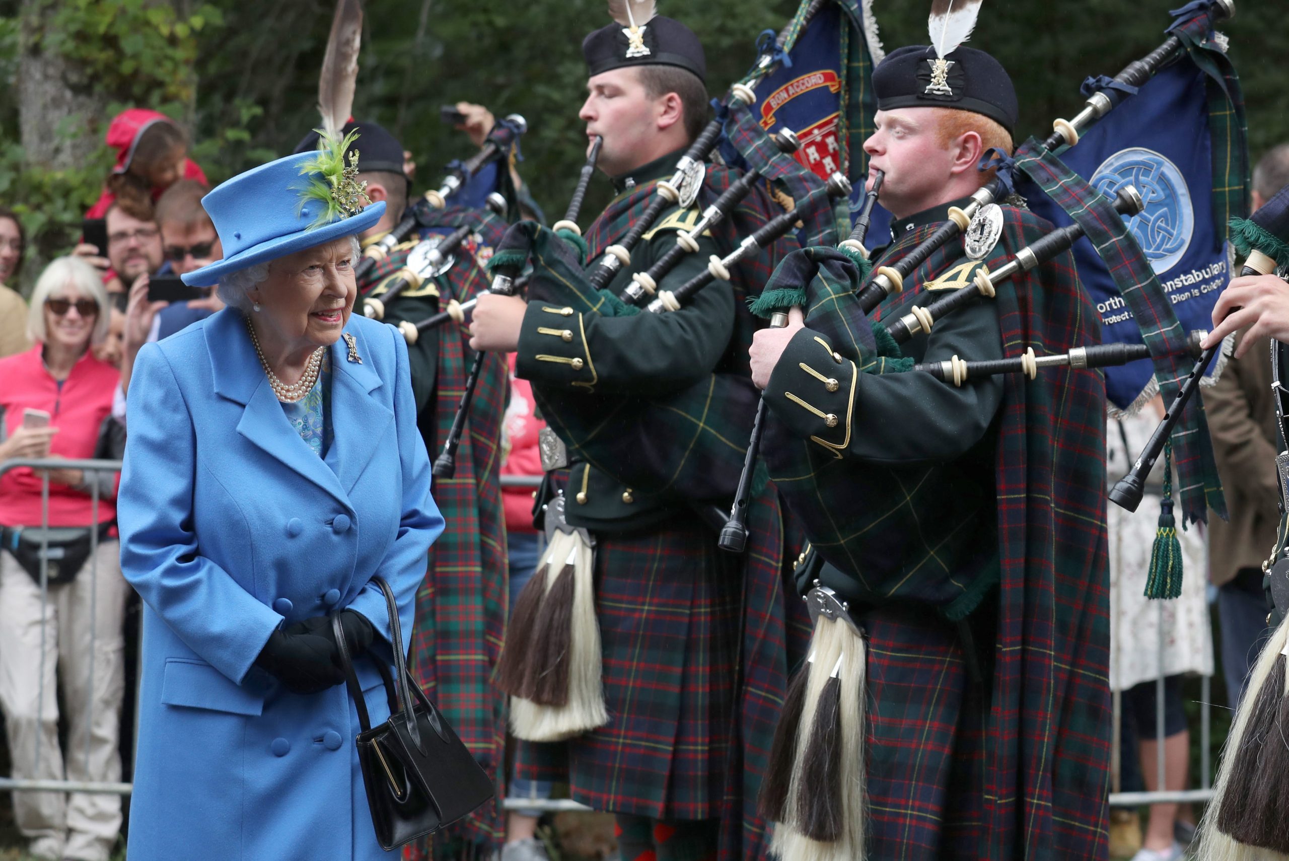 Die britische Königin Elisabth II läuft bei ihrer Ankunft an ihrer Sommerresidenz an Dudelsackspielern des „Royal Regiment of Scotland“ vorbei