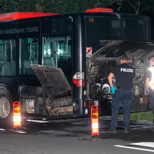 Polizisten inspizieren den hinteren Teil des Busses. Hier brach das Feuer aus.