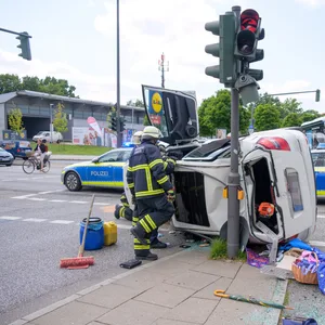 Mercedes liegt auf der Seite, Ampel beschädigt