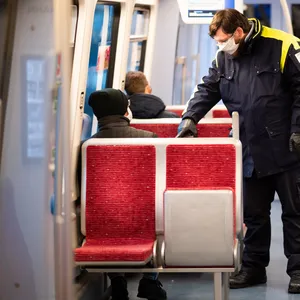 Ein Mitarbeiter der Hochbahn kontrolliert in einem Zug der Hochbahn die Fahrkarten.