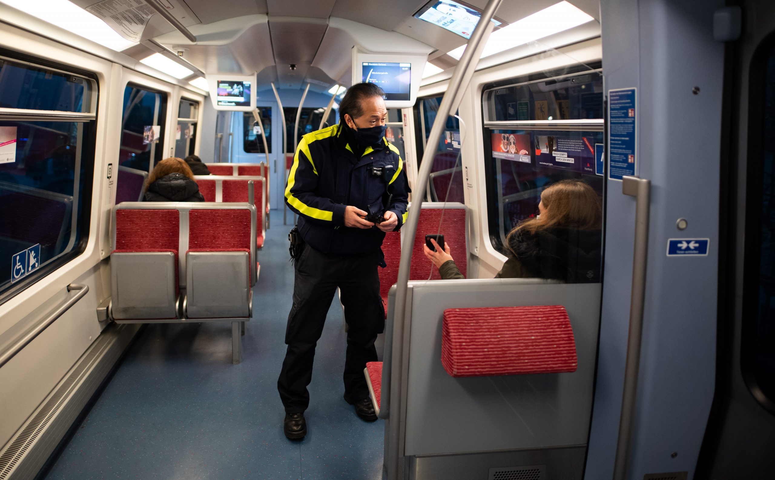Ein Mitarbeiter der Hochbahn kontrolliert die Fahrkarten in einer U-Bahn.