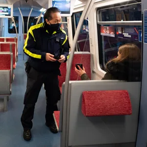 Ein Mitarbeiter der Hochbahn kontrolliert die Fahrkarten in einer U-Bahn.