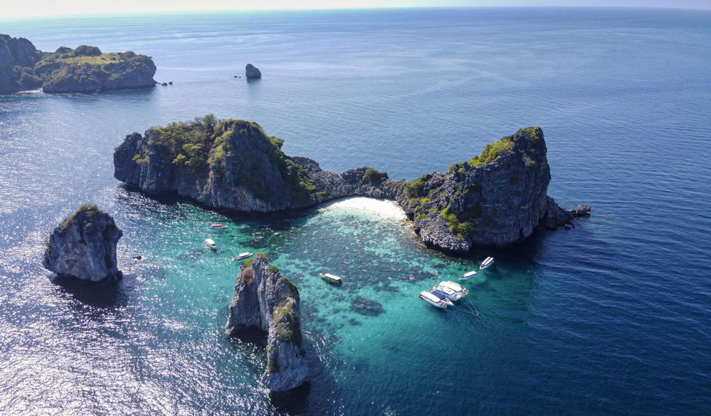 Felsen im tiefblauen Wasser vor Thailands Küste