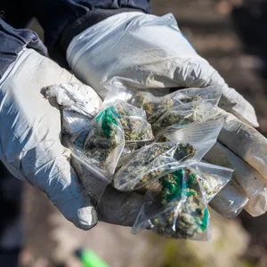 Eine Polizistin hält Drogen in der Hand.