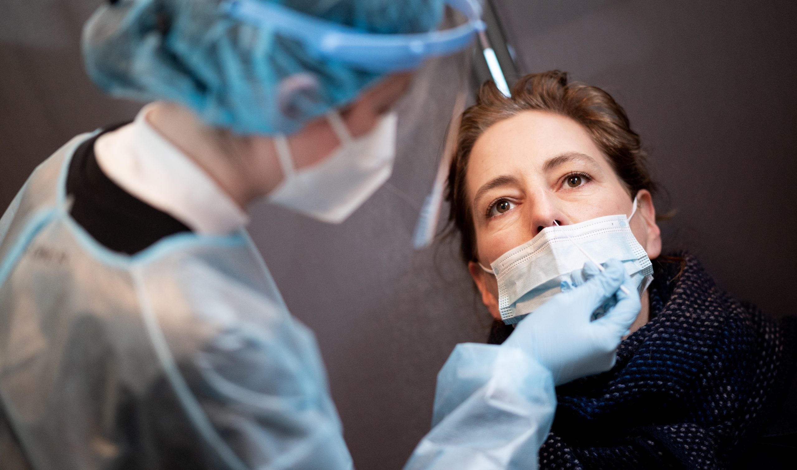Eine Frau lässt sich in einem Corona-Schnelltest-Zentrum mit einem Nasenabstrich auf das Coronavirus testen.