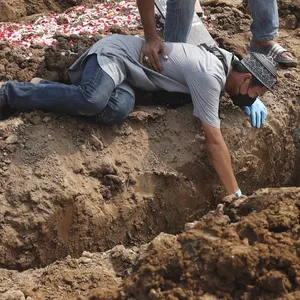 Ein Mann fällt auf einem Friedhof in Jakarta zu Boden, während der Beerdigung eines Verwandten, der an Covid-19 gestorben ist.