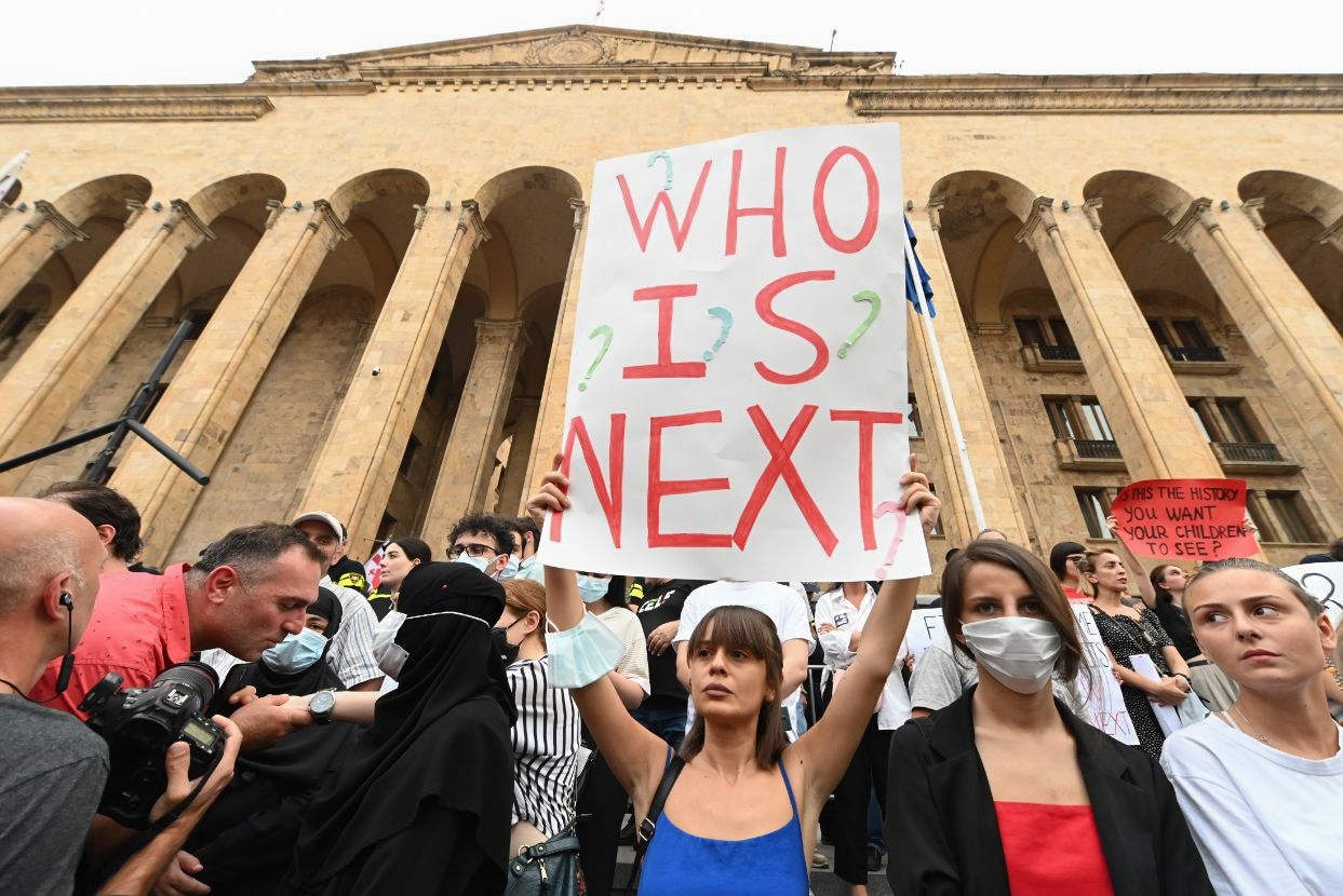 Eine Demonstrantin hält ein Schild mit der Aufschrift „Who is next?“ in die Höhe.