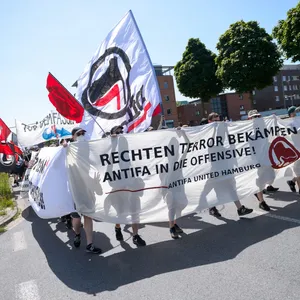 Demonstranten zeigen ein Plakat mit der Aufschrift „Rechten Terror bekämpfen – Antifa in die Offensive“.