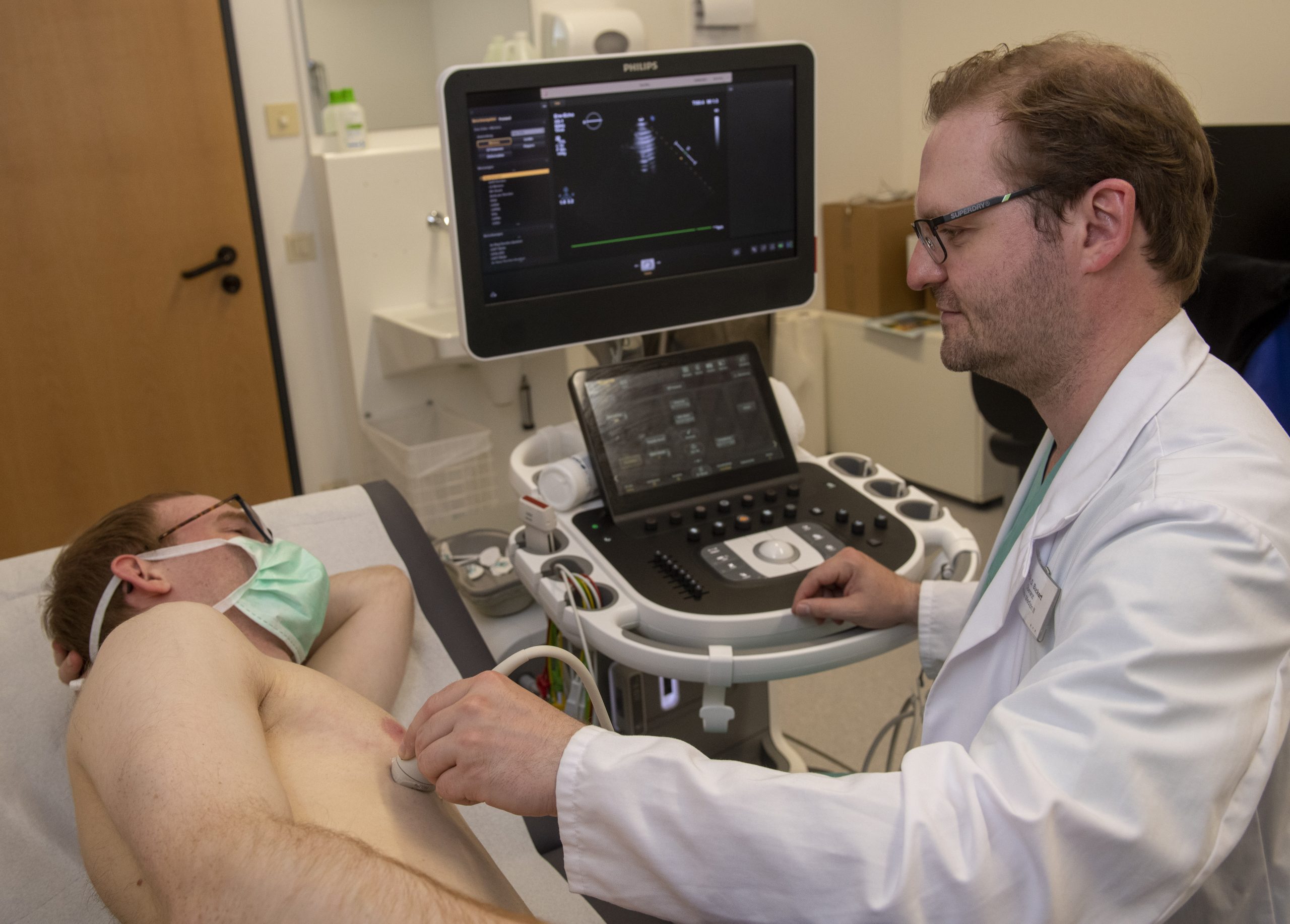 Ein Arzt macht einen Ultraschall vom Herzen seines Patienten.