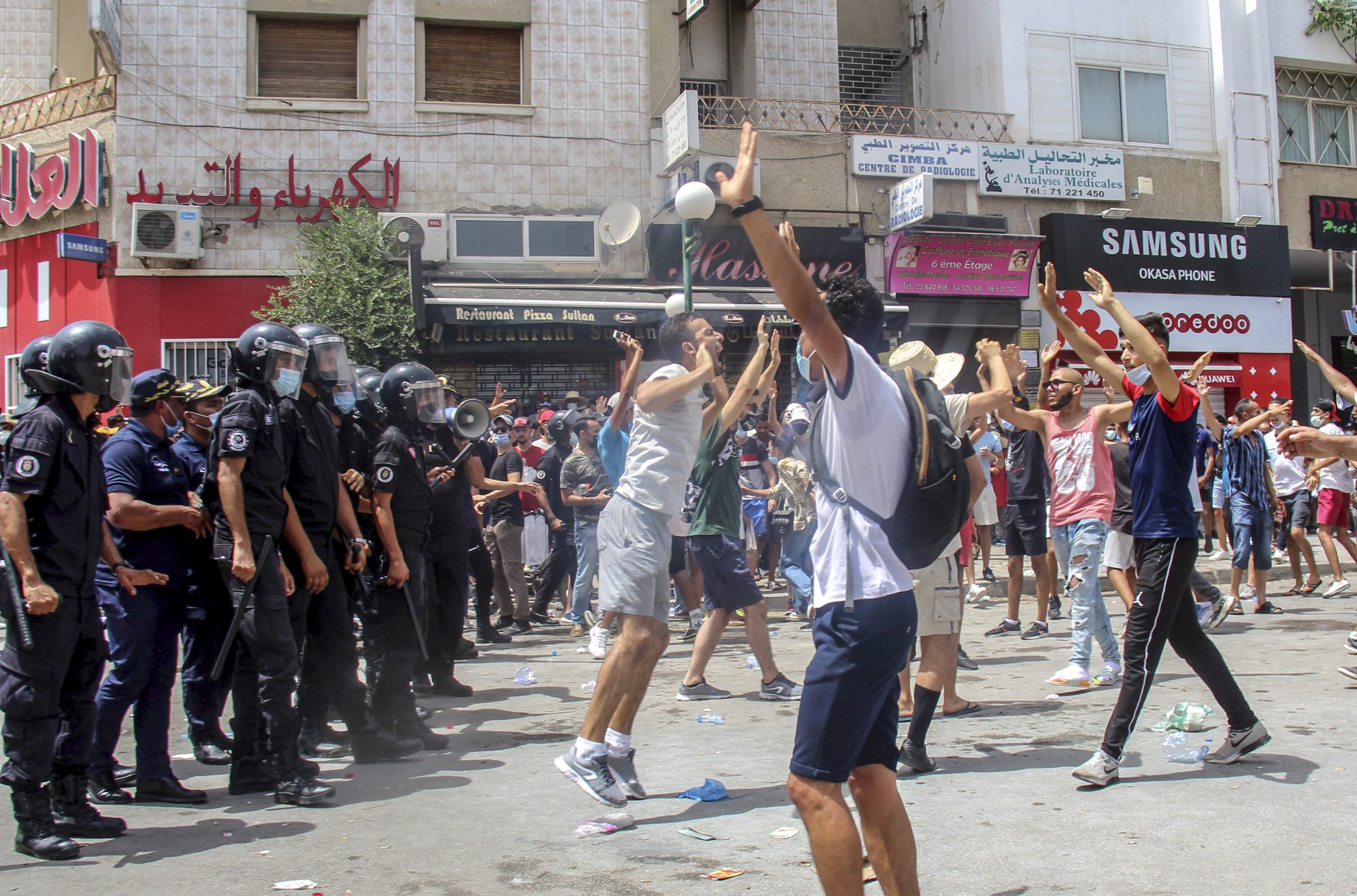 Polizisten stehen Demonstranten in Tunesien gegenüber.