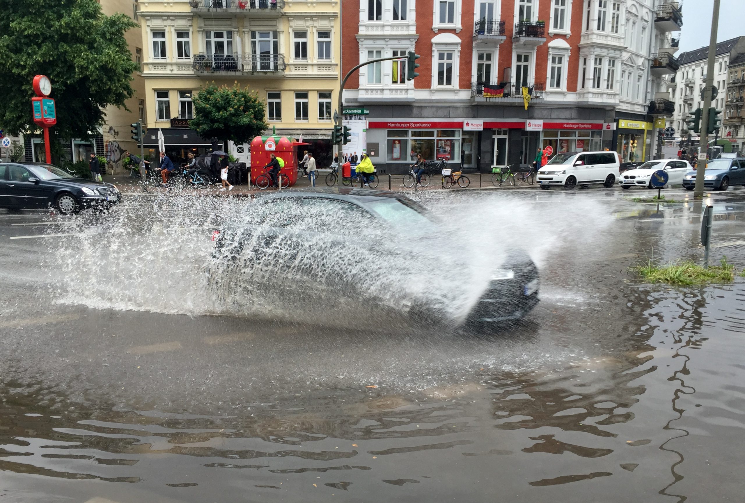 Auto fährt auf überfluteter Straße