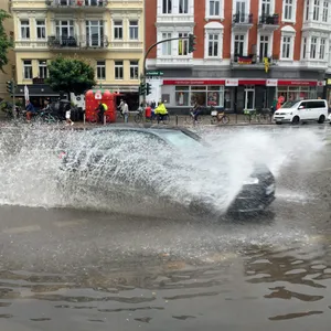 Auto fährt auf überfluteter Straße