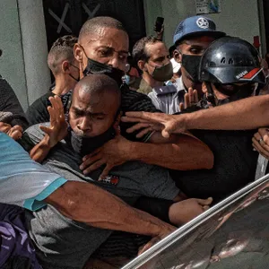 Sicherheitskräfte nehmen gewaltsam einen Demonstranten fest.