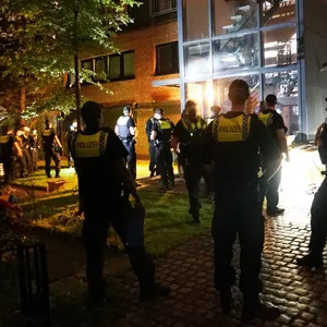 Polizisten vor dem Gebäude am Kronsaalsweg, wo fast 70 Leute eine Swinger-Party feiern wollten.