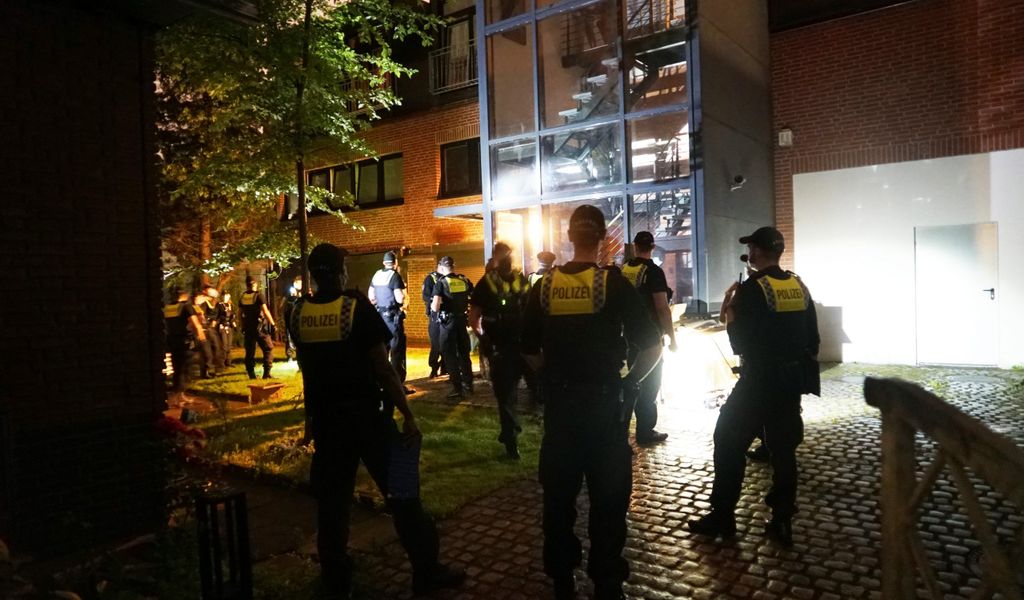 Polizisten vor dem Gebäude am Kronsaalsweg, wo fast 70 Leute eine Swinger-Party feiern wollten.