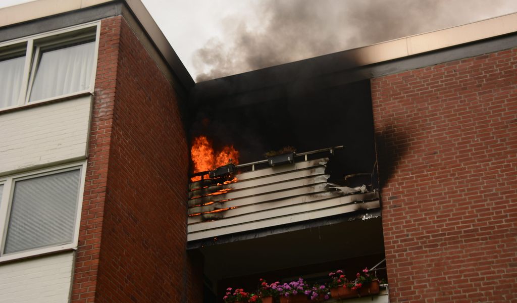 Der Dachstuhl eines Mehrfamilienhauses steht in Flammen.