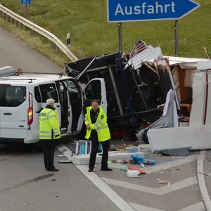 Polizeibeamte vor den Trümmerteilen der zwei am Unfall beteiligten Fahrzeuge.