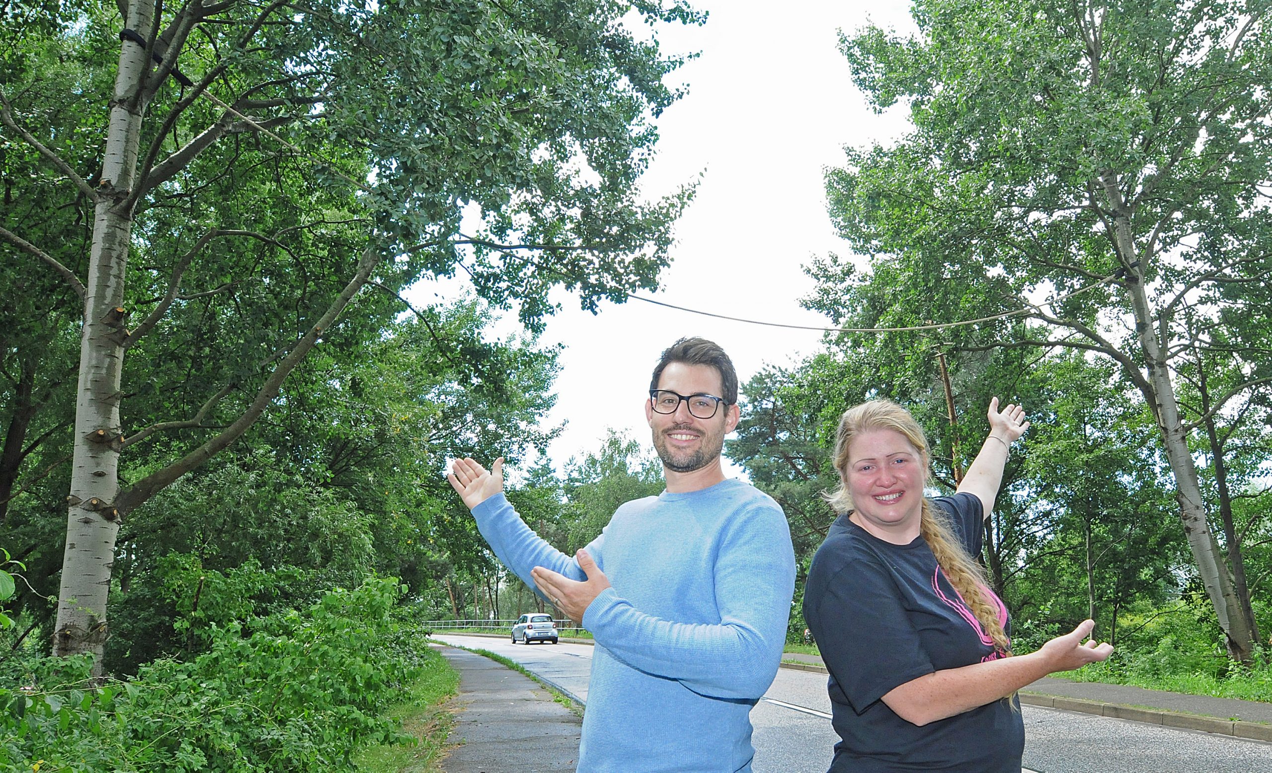Vanessa Haloui (40) von der Hamburger Igel- und Wildtierstation Looki und Julian Emrich (35) von der CDU Bergedorf freuen sich über die Eichhörnchenbrücke über die Straße Pollhof.