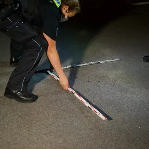 Ein Polizist untersucht Blutspuren am Tatort in Hamburg.
