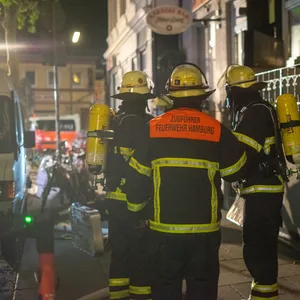 Einsatzkräfte der Feuerwehr vor dem Wohnhaus an der Hopfenstraße.