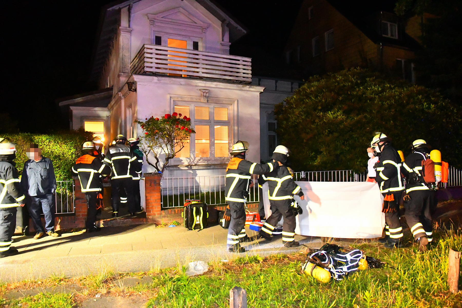 Einsatzkräfte der Feuerwehr vor dem Einfamilienhaus in Hamburg-Lokstedt.