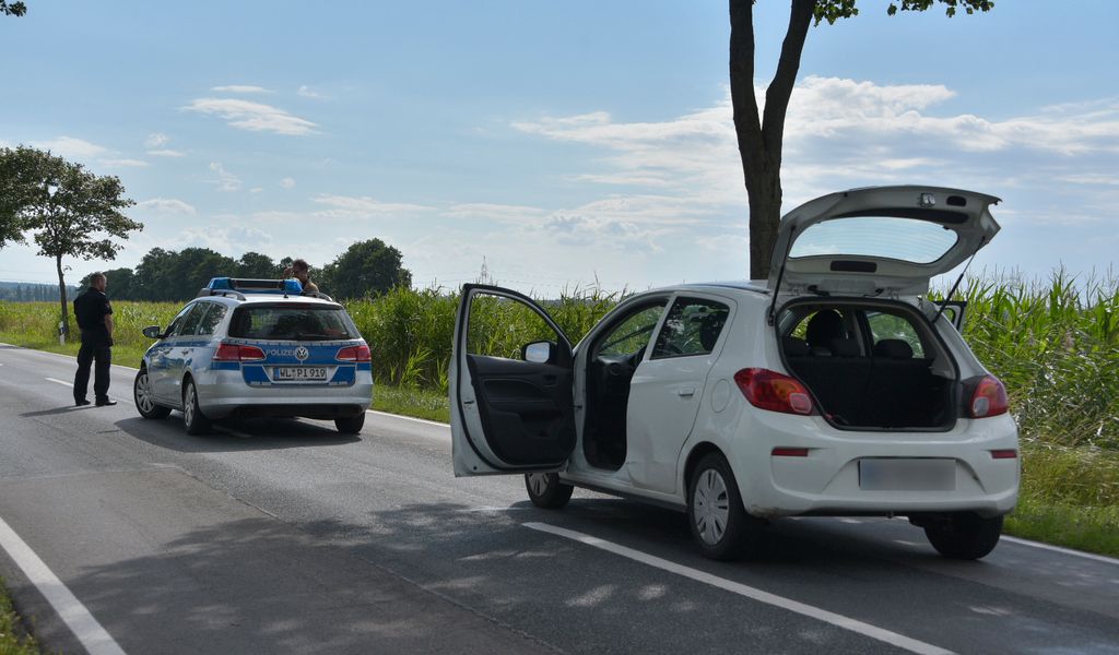 Ein Polizeiauto und ein weißer Opel Corsa auf einer Landstraße im Kreis Harburg