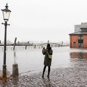 Eine Touristin fotografiert die steigende Flut auf dem Fischmarkt im Jahr 2018.