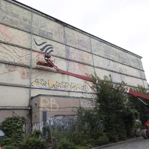 Hamburger Künstler bringt Farbe auf Altonas Energiebunker in der Schomburgstrasse.
