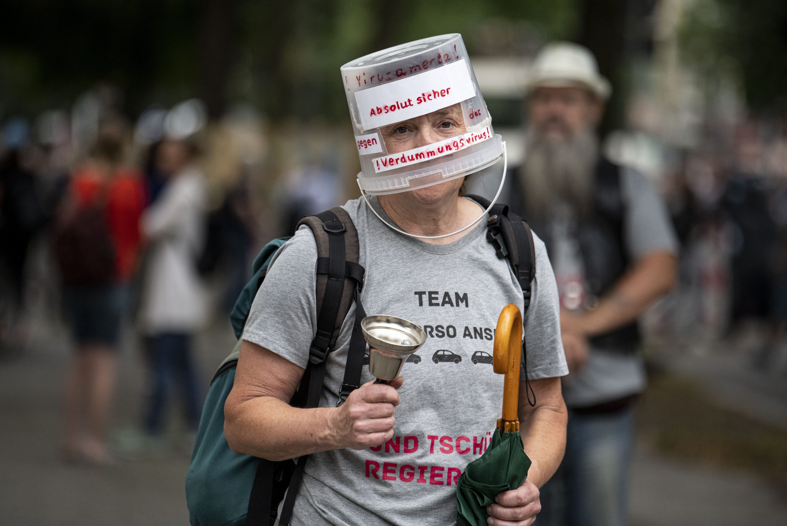 Ein „Querdenken“-Demonstrant läuft mit Plastikeimer auf dem Kopf durch Berlin.