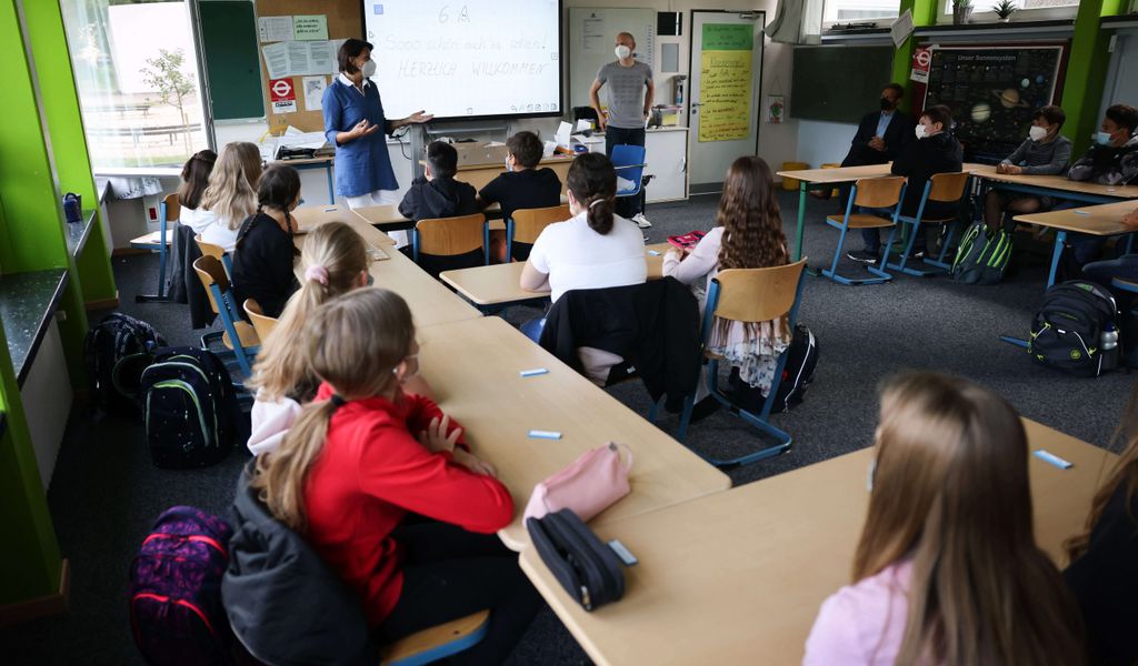 Elisabeth Bayersdörfer (l) Klassenlehrerin der Klasse 6a am Goethe-Gymnasium in Hamburg-Lurup, spricht zu den Schülerinnen und Schülern am ersten Schultag nach den Ferien.