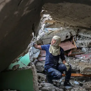 Ein Feuerwehrmann sucht zwischen den Trümmern eines von einem Erdbeben zerstörten Hauses nach Überlebenden.