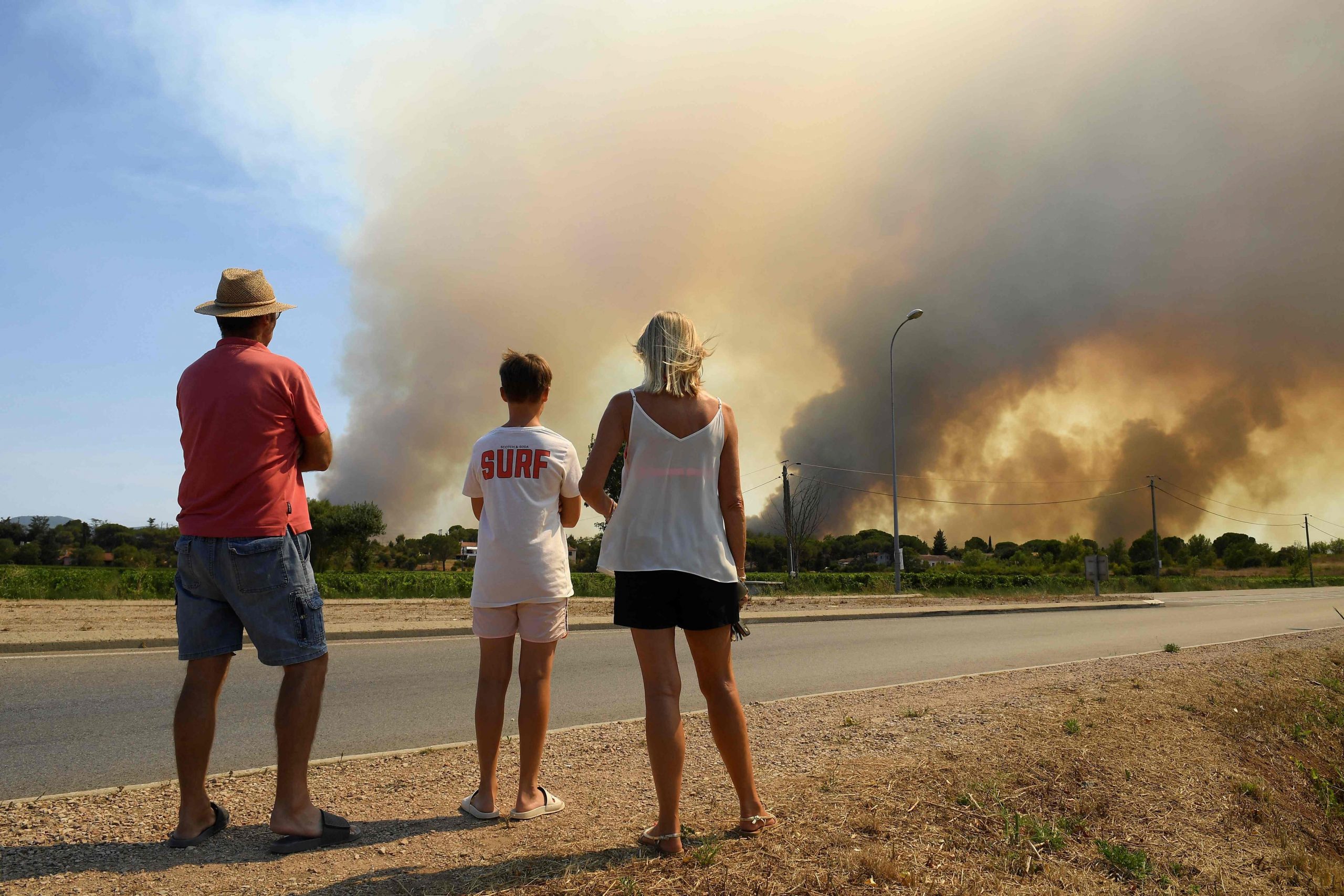 Touristen beobachten Waldbrände nördlich von Grimaud in Südfrankreich.