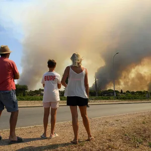 Touristen beobachten Waldbrände nördlich von Grimaud in Südfrankreich.