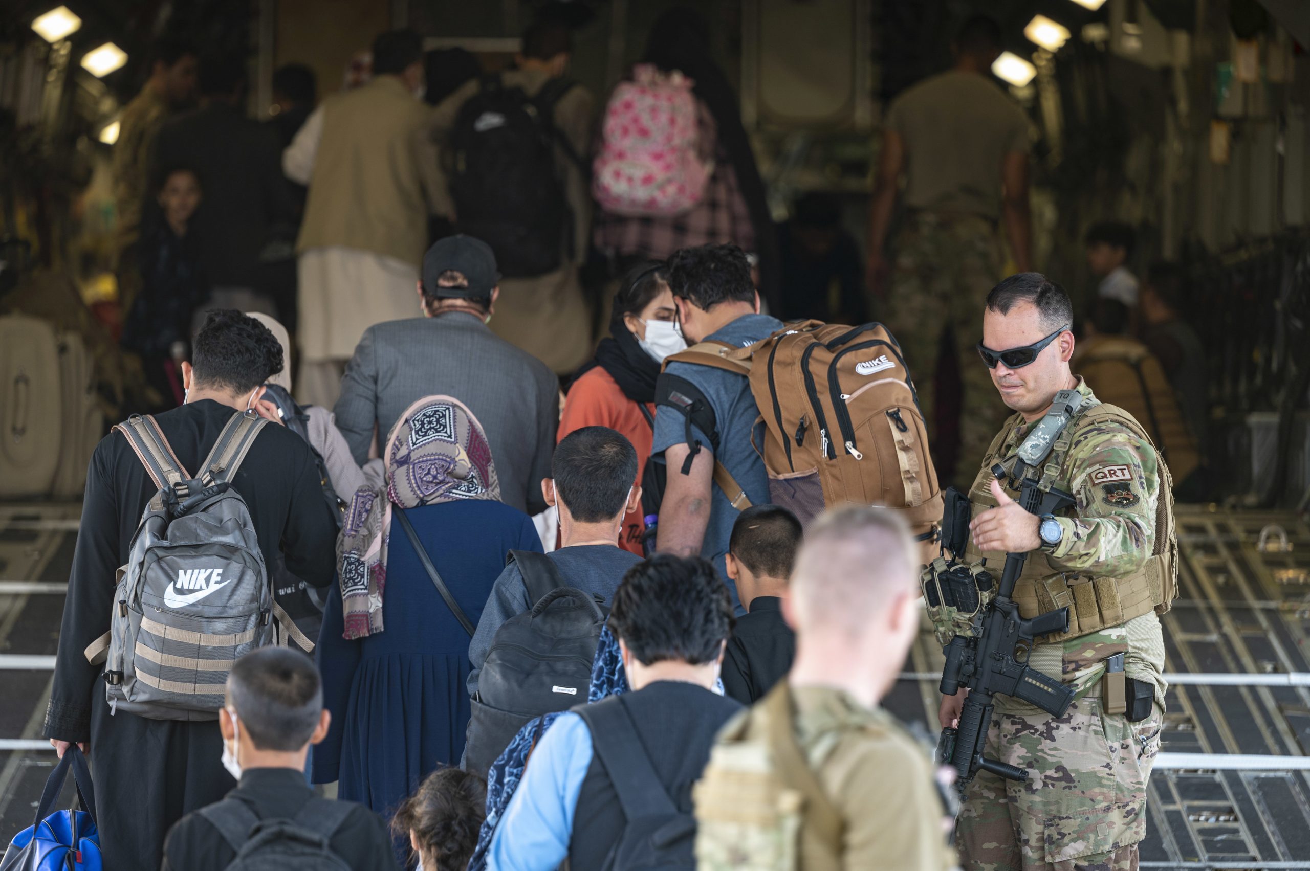 Amerikanische Soldaten begleiten Flüchtende an Bord eines Militärflugzeuges der US-Air-Force.