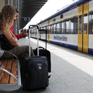 2 Personen warten auf die Bahn.